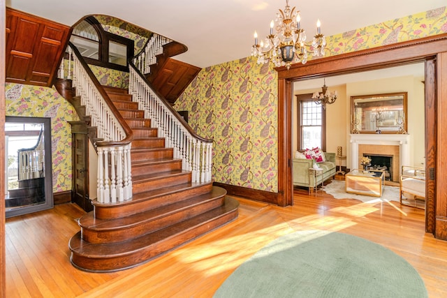 stairway with hardwood / wood-style flooring and wallpapered walls