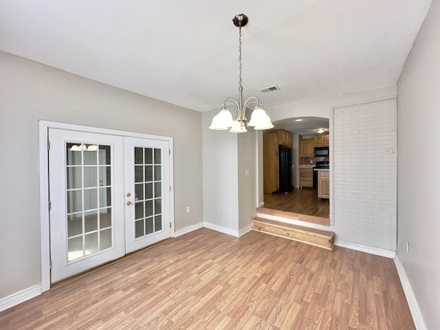 unfurnished dining area with light wood-type flooring, french doors, visible vents, and baseboards