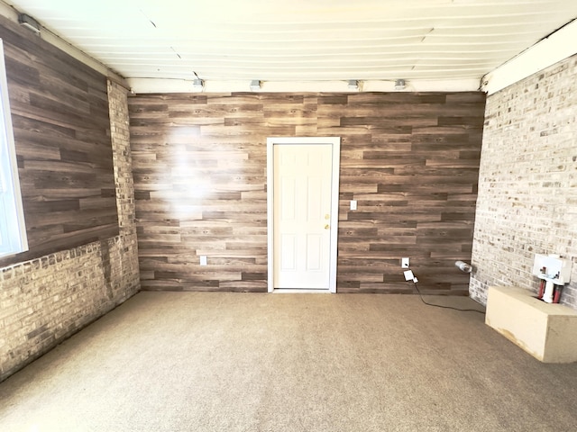 carpeted empty room with brick wall and wooden walls