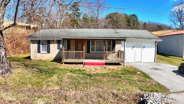 single story home featuring a porch, brick siding, metal roof, and a front lawn