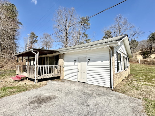 exterior space with driveway and metal roof