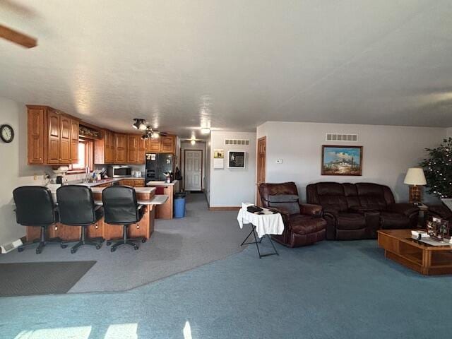 living area with carpet floors and visible vents