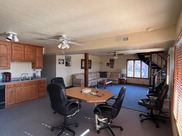 office with dark carpet, visible vents, a sink, and a textured ceiling