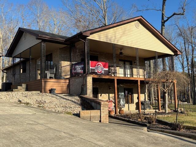 view of front of home with driveway and a balcony