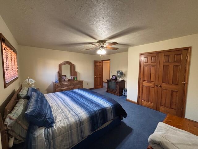 bedroom featuring carpet floors, a textured ceiling, baseboards, and a ceiling fan