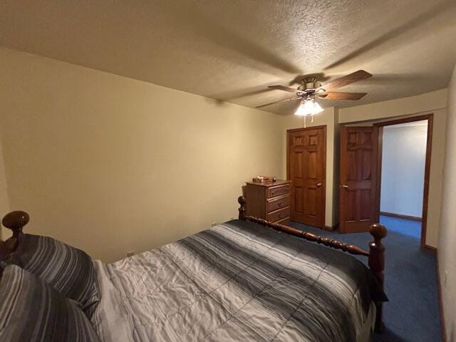 bedroom featuring a ceiling fan, dark carpet, and a textured ceiling