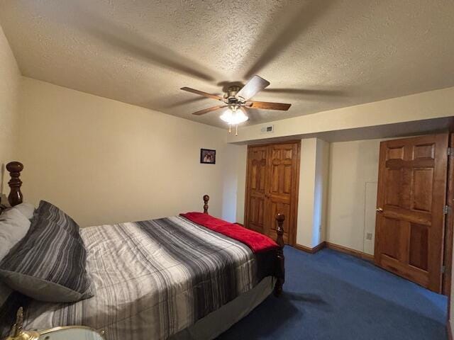 carpeted bedroom with ceiling fan, baseboards, and a textured ceiling