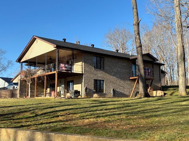 back of property featuring a yard and a balcony