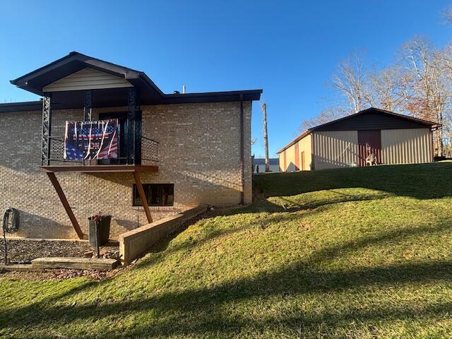 view of property exterior with brick siding and a yard