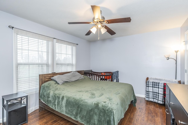 bedroom featuring dark wood-type flooring, ceiling fan, and baseboards