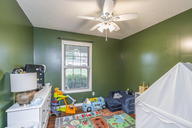 rec room featuring a ceiling fan, baseboards, and wood finished floors