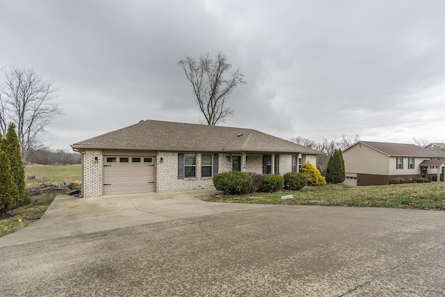 single story home featuring a garage, driveway, brick siding, and a shingled roof