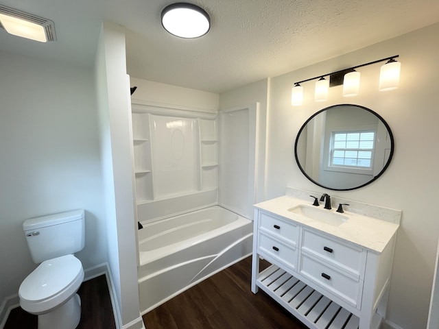 full bath featuring vanity, wood finished floors, visible vents, a textured ceiling, and toilet