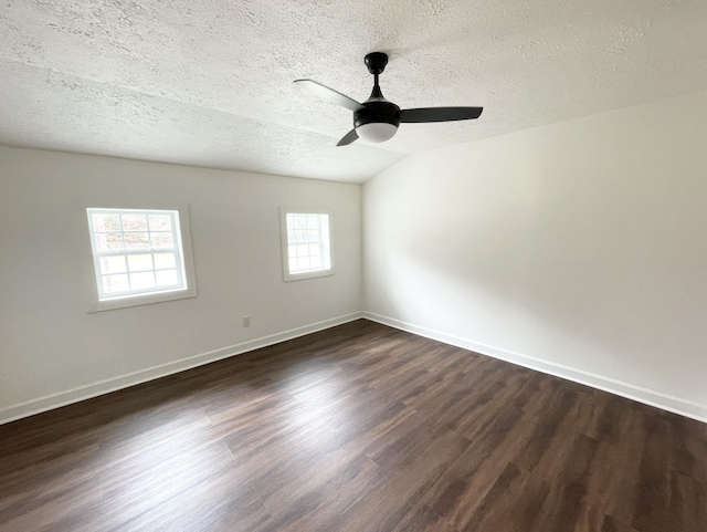 empty room featuring ceiling fan, baseboards, a textured ceiling, and dark wood-style floors