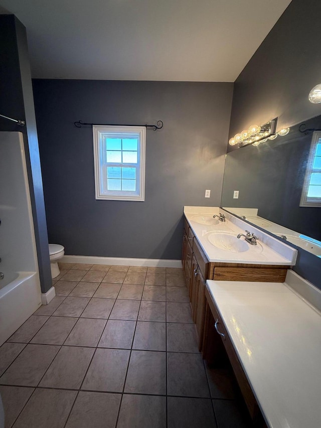 full bathroom featuring tile patterned flooring, toilet, a sink, baseboards, and double vanity