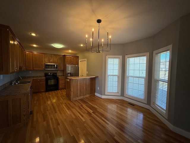 kitchen with a chandelier, stainless steel appliances, dark wood-style flooring, a sink, and visible vents