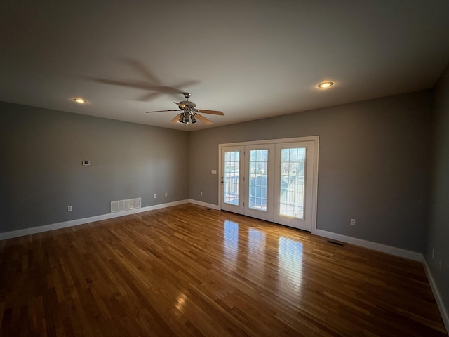 spare room featuring baseboards, visible vents, and wood finished floors