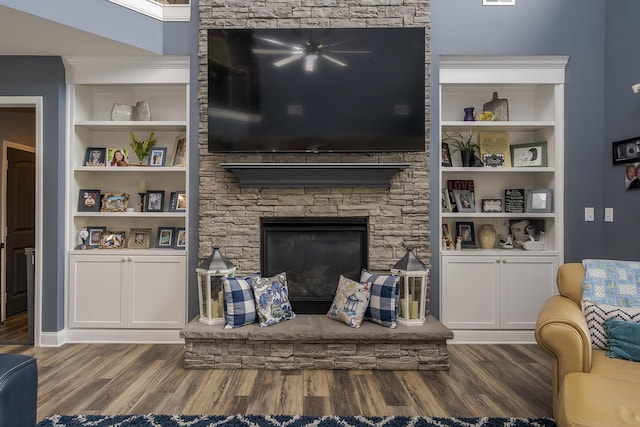 living area featuring a stone fireplace and wood finished floors