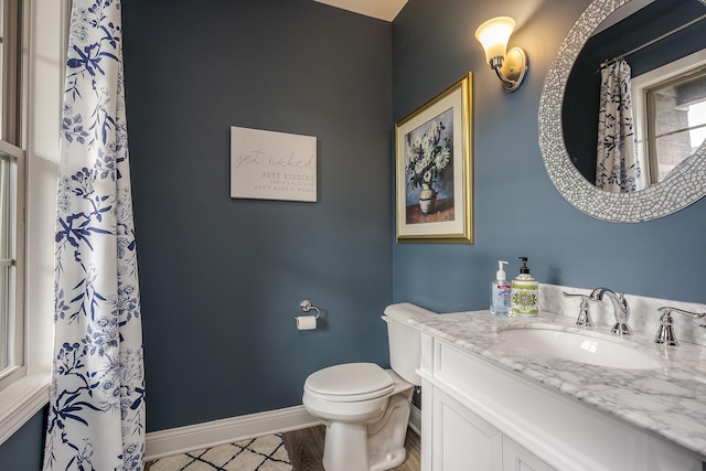 full bathroom featuring wood finished floors, vanity, toilet, and baseboards