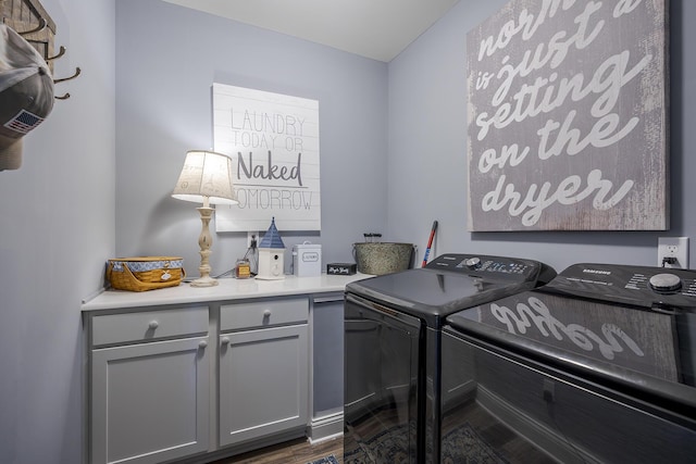 washroom featuring cabinet space, washing machine and dryer, and dark wood-style floors