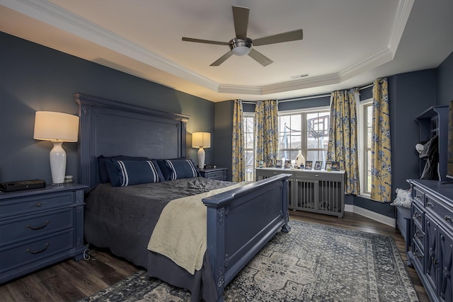 bedroom featuring ceiling fan, visible vents, dark wood finished floors, ornamental molding, and a raised ceiling