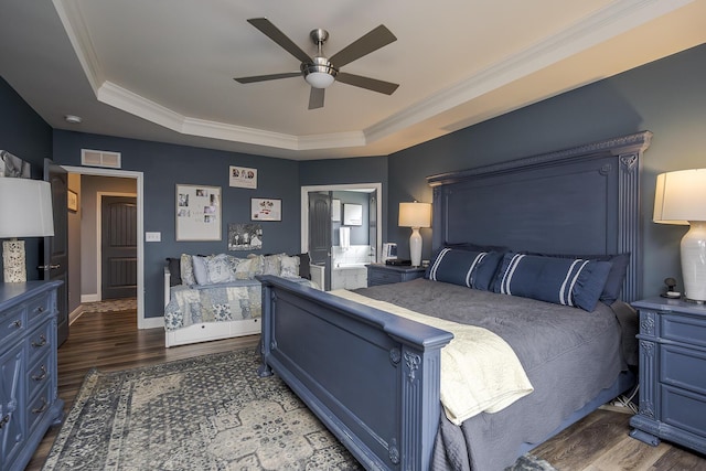 bedroom featuring ornamental molding, wood finished floors, a raised ceiling, and visible vents