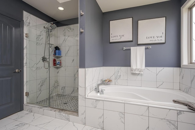 bathroom with a stall shower, marble finish floor, and a garden tub