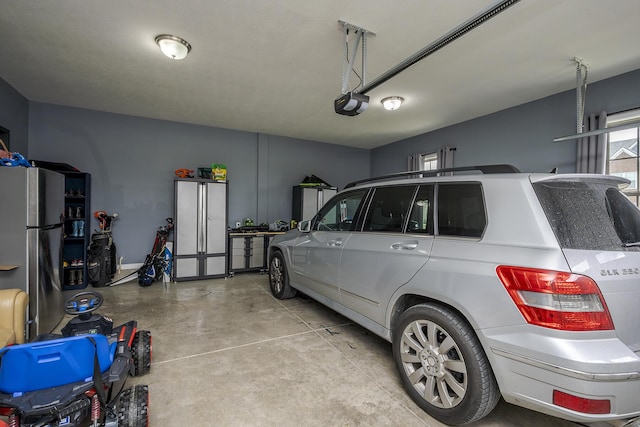 garage featuring a garage door opener and freestanding refrigerator