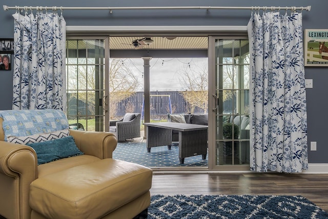 sitting room with a healthy amount of sunlight, baseboards, and wood finished floors