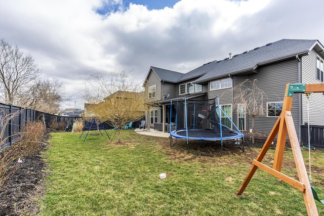 view of yard featuring a fenced backyard, a trampoline, a playground, and a patio