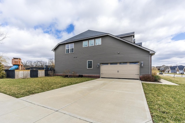 view of side of home featuring a garage, concrete driveway, a playground, and a yard