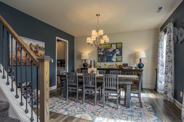 dining room featuring visible vents, stairway, wood finished floors, a chandelier, and baseboards