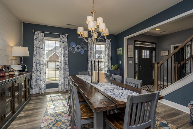 dining space featuring a notable chandelier, wood finished floors, visible vents, and a healthy amount of sunlight