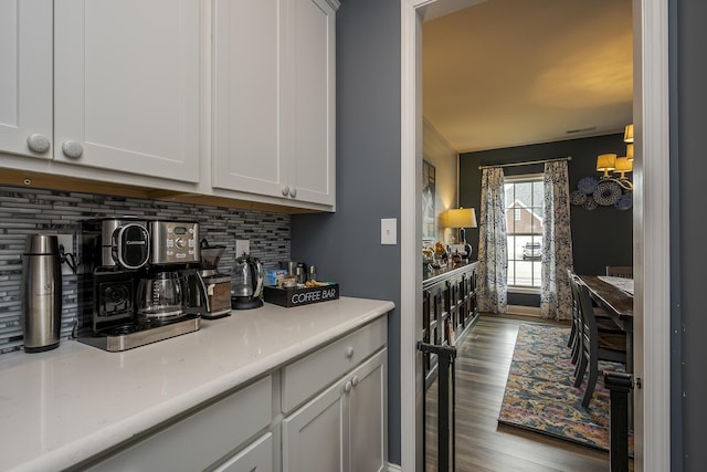 bar featuring dark wood-type flooring and decorative backsplash