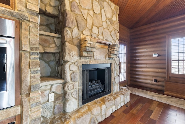 unfurnished living room with a stone fireplace, wood ceiling, vaulted ceiling, log walls, and wood-type flooring