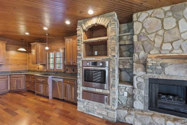 kitchen with stainless steel appliances, dark wood finished floors, a fireplace, and a warming drawer