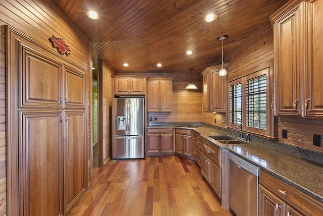 kitchen with brown cabinets, recessed lighting, appliances with stainless steel finishes, a sink, and wood finished floors