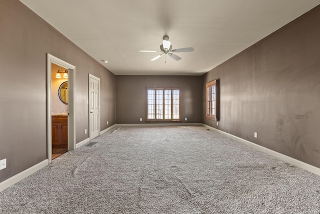 spare room with ceiling fan, carpet flooring, visible vents, and baseboards