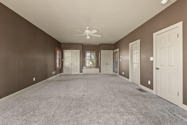 unfurnished living room featuring a ceiling fan, visible vents, baseboards, and carpet flooring