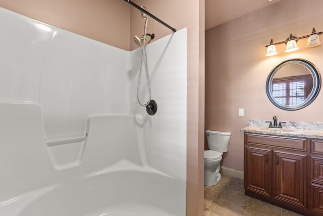 bathroom featuring baseboards, vanity, toilet, and tile patterned floors