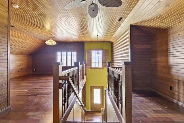 corridor featuring wood walls, an upstairs landing, and hardwood / wood-style flooring