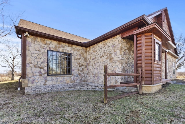 view of side of home featuring roof with shingles