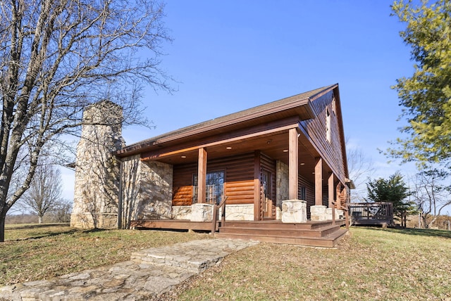 view of front of home with stone siding, a front lawn, and covered porch