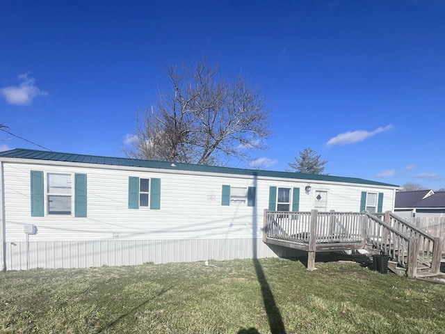 manufactured / mobile home featuring a front yard, metal roof, and a deck