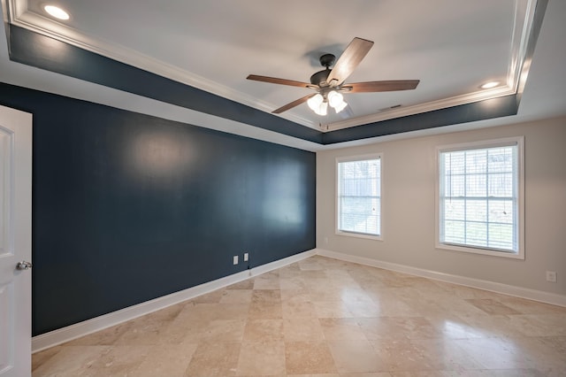 spare room featuring visible vents, baseboards, ceiling fan, ornamental molding, and a raised ceiling