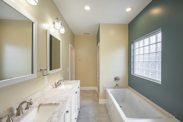 bathroom with tile patterned flooring, recessed lighting, a tub with jets, and a sink