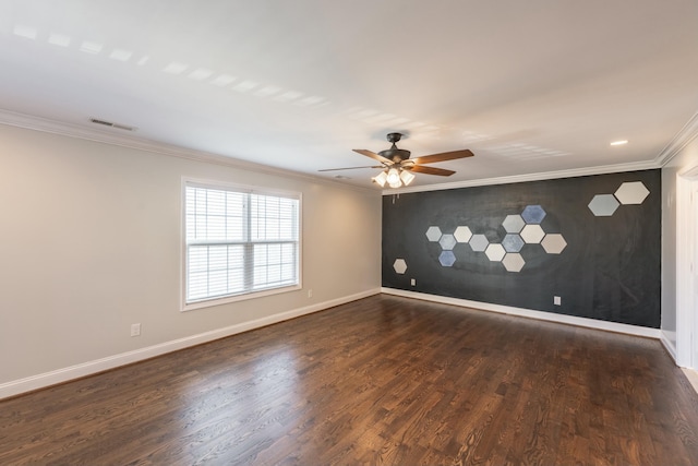 spare room with visible vents, an accent wall, baseboards, ornamental molding, and dark wood-style flooring