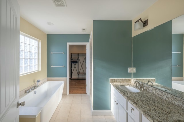 bathroom with tile patterned flooring, visible vents, a walk in closet, a bath, and vanity