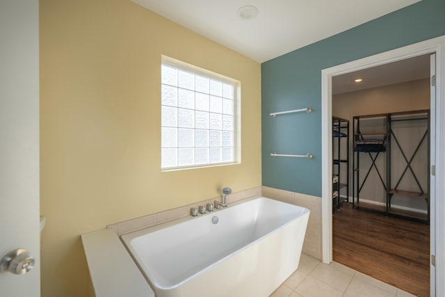 full bath featuring tile patterned floors and a soaking tub