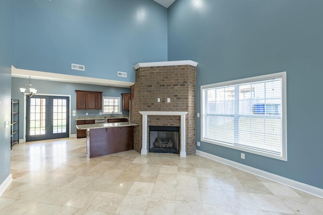 kitchen featuring visible vents, a breakfast bar, a peninsula, a fireplace, and french doors